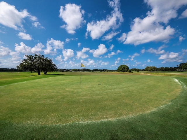 view of home's community with golf course view and a yard