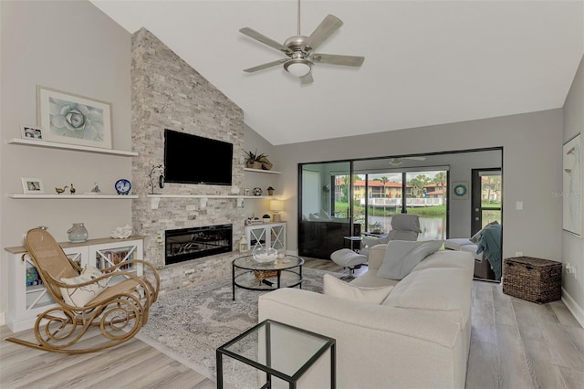 living room featuring a fireplace, high vaulted ceiling, ceiling fan, and light hardwood / wood-style floors