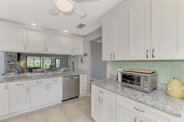 kitchen featuring white cabinetry, light tile patterned floors, ceiling fan, decorative backsplash, and stainless steel dishwasher