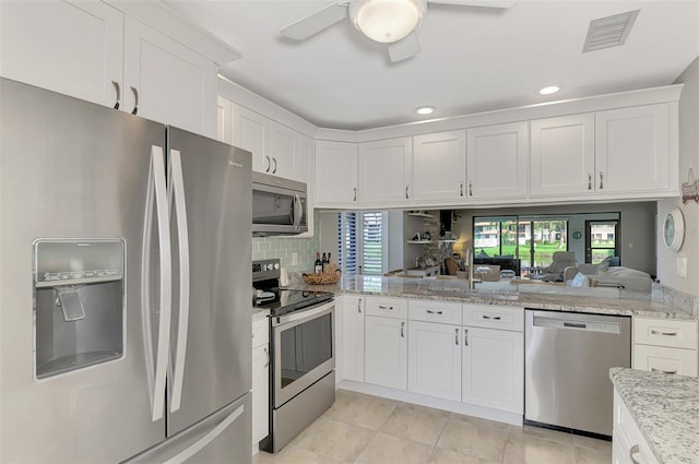 kitchen with a healthy amount of sunlight, ceiling fan, appliances with stainless steel finishes, and white cabinetry