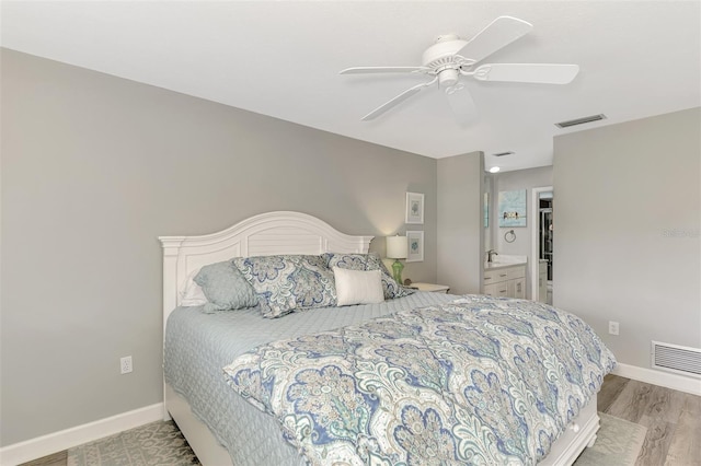 bedroom with ceiling fan, ensuite bathroom, and light hardwood / wood-style floors