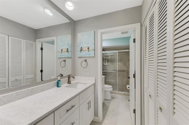 bathroom featuring vanity, toilet, walk in shower, and tile patterned floors