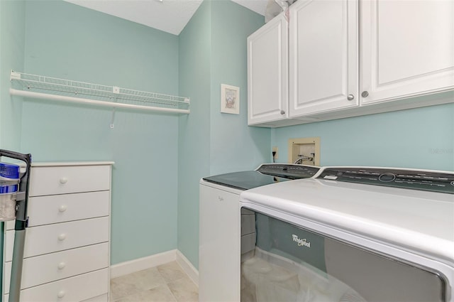 laundry area with cabinets, washer and dryer, and light tile patterned flooring