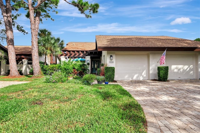 view of front of property featuring a garage and a front lawn