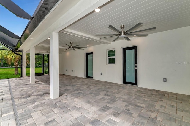 view of patio featuring glass enclosure and ceiling fan