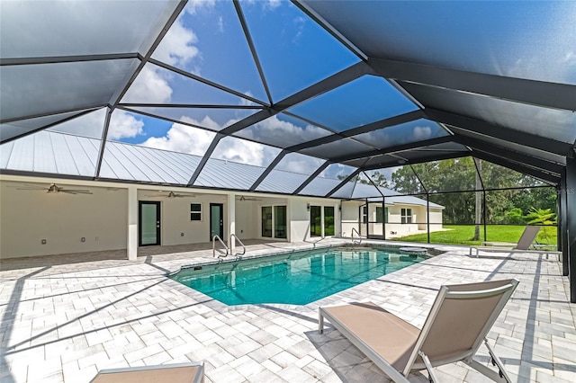 outdoor pool with glass enclosure, a patio, and ceiling fan