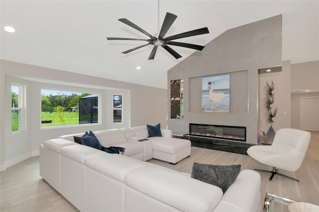 living room with recessed lighting, a glass covered fireplace, light wood-style flooring, and a ceiling fan