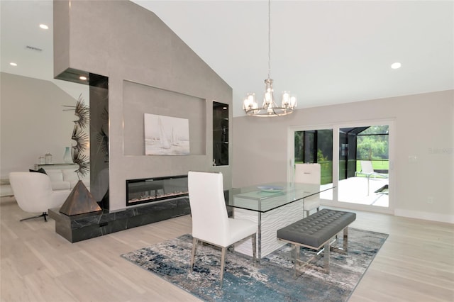 dining area featuring high vaulted ceiling, a tiled fireplace, wood finished floors, recessed lighting, and baseboards