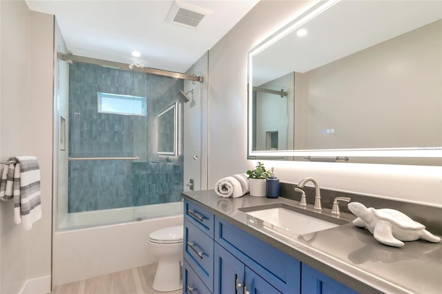 full bathroom with shower / bath combination with glass door, visible vents, toilet, and vanity