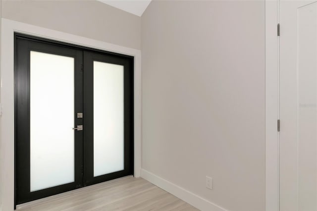 interior space with light wood-style flooring, french doors, and baseboards