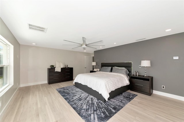 bedroom featuring visible vents, baseboards, light wood-style floors, and a ceiling fan