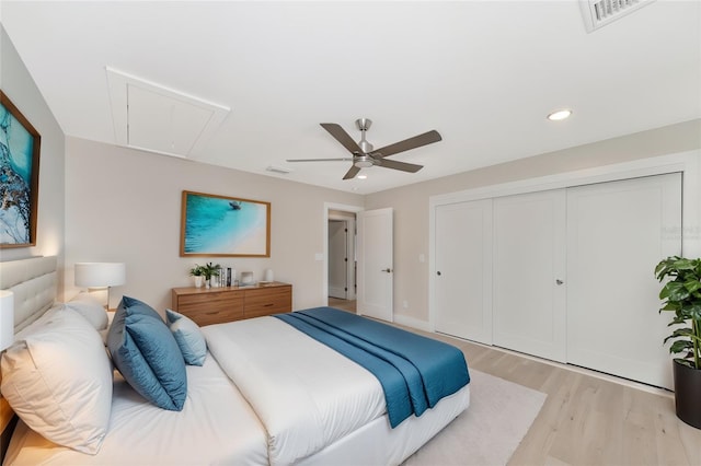 bedroom featuring visible vents, attic access, light wood-type flooring, recessed lighting, and a closet