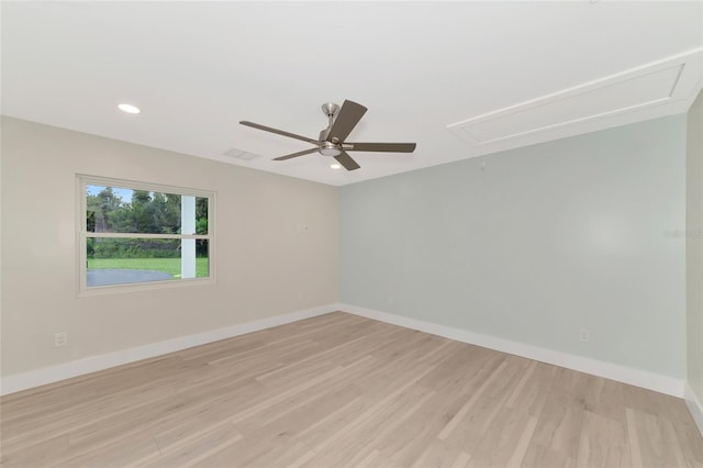 empty room with baseboards, light wood-style floors, attic access, and ceiling fan