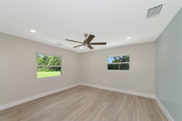 spare room featuring a healthy amount of sunlight, visible vents, and baseboards