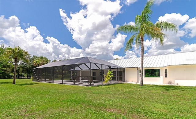 exterior space with a standing seam roof, a yard, stucco siding, a lanai, and metal roof