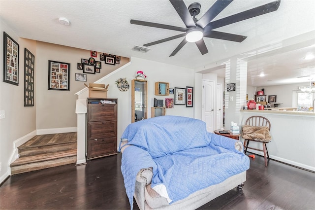 bedroom with a textured ceiling, ceiling fan, and dark hardwood / wood-style floors