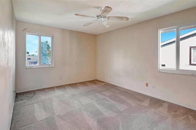 carpeted spare room featuring ceiling fan