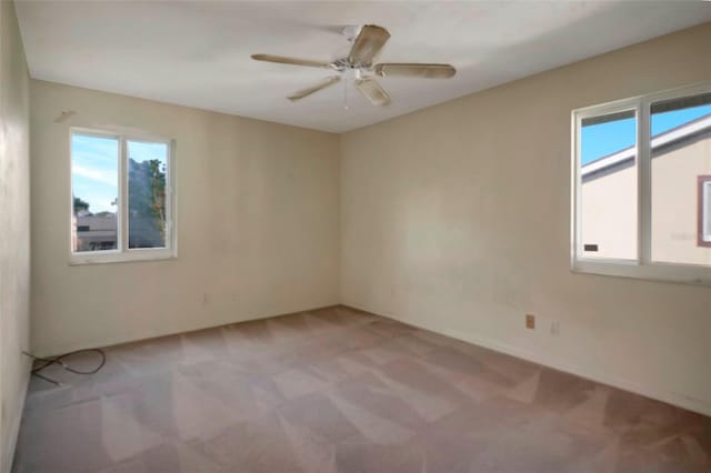 carpeted empty room featuring a wealth of natural light and ceiling fan