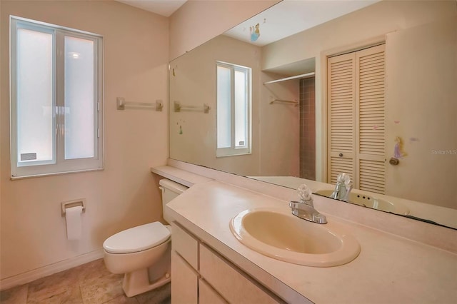 bathroom with tile patterned flooring, plenty of natural light, vanity, and toilet