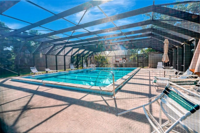 view of pool with glass enclosure and a patio