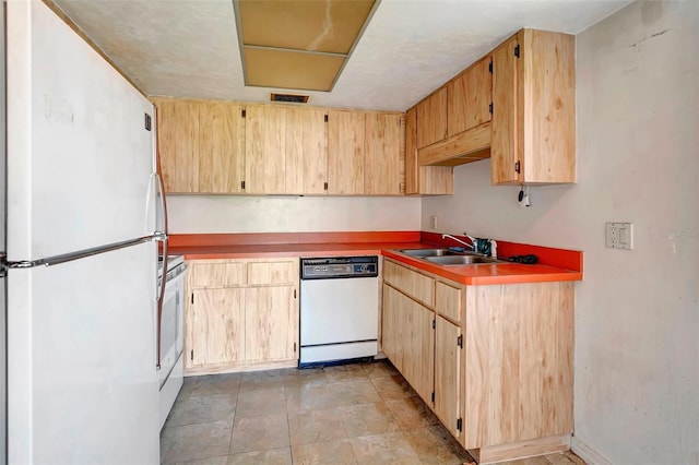 kitchen with light brown cabinets, white appliances, and sink