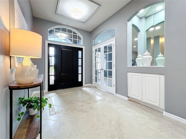 foyer entrance with baseboards and french doors