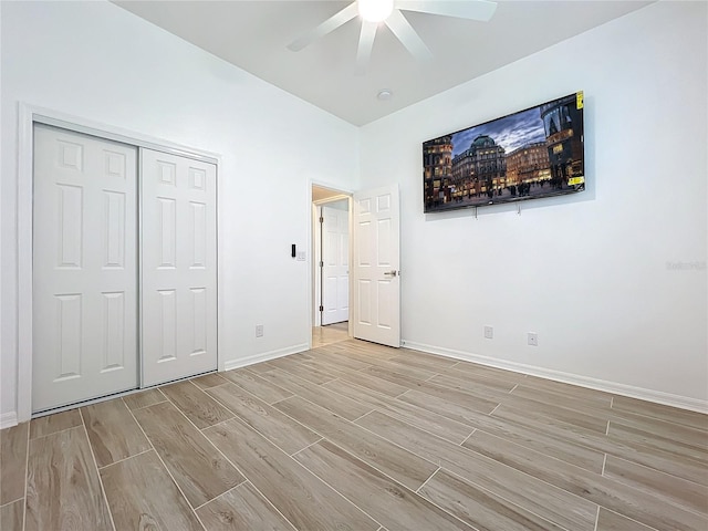 unfurnished bedroom with ceiling fan, baseboards, a closet, and wood finish floors