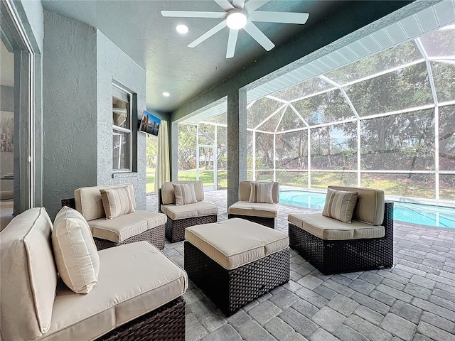 view of patio featuring an outdoor pool, glass enclosure, ceiling fan, and an outdoor living space