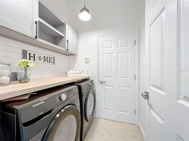 washroom featuring cabinet space and washer and clothes dryer