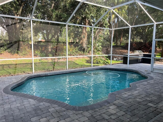 outdoor pool with glass enclosure and a patio