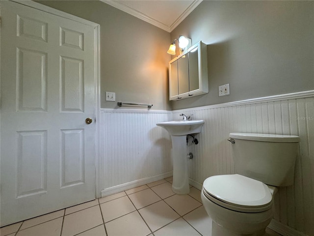 bathroom with tile patterned flooring, crown molding, and toilet