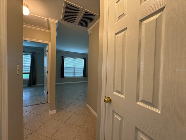 hall featuring light tile patterned flooring and crown molding