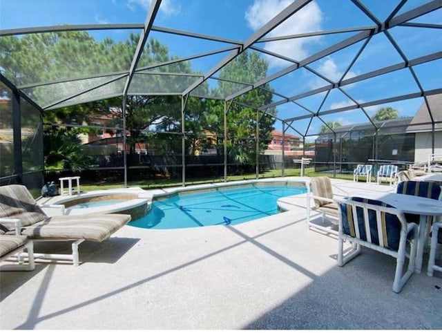 view of swimming pool with glass enclosure, an in ground hot tub, and a patio area