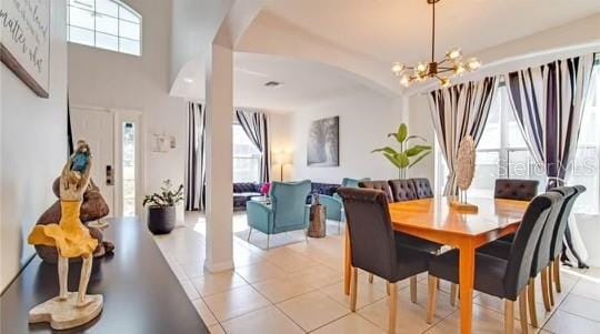 tiled dining space with an inviting chandelier and a wealth of natural light