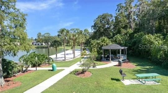 surrounding community with a gazebo, a yard, and a water view