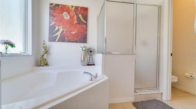 bathroom featuring plus walk in shower, tile patterned floors, and toilet