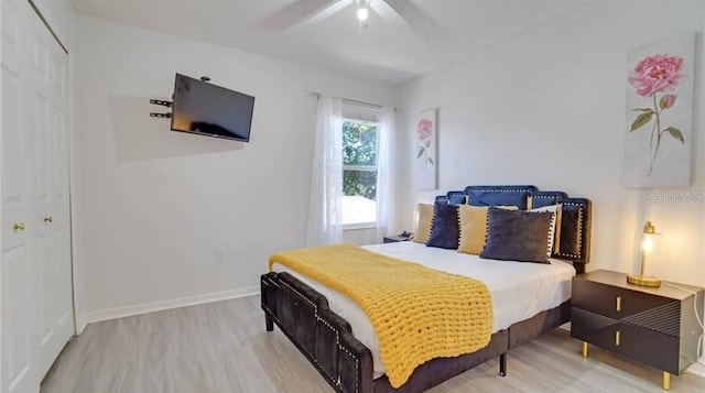 bedroom with a closet, hardwood / wood-style flooring, and ceiling fan