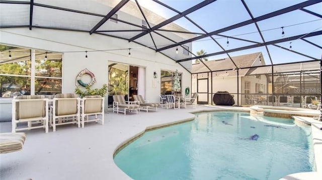 view of pool with an in ground hot tub, a patio area, and a lanai