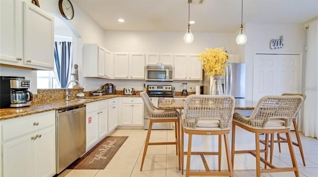 kitchen featuring dark stone countertops, sink, stainless steel appliances, and white cabinets