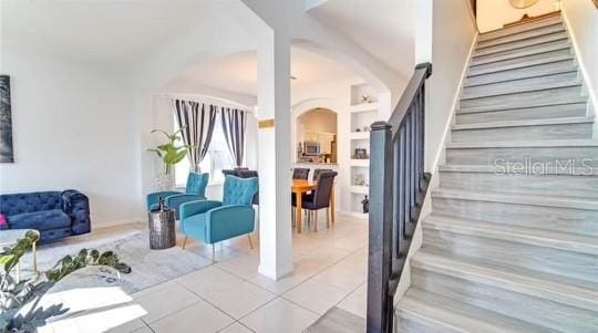 stairway with built in shelves and tile patterned floors