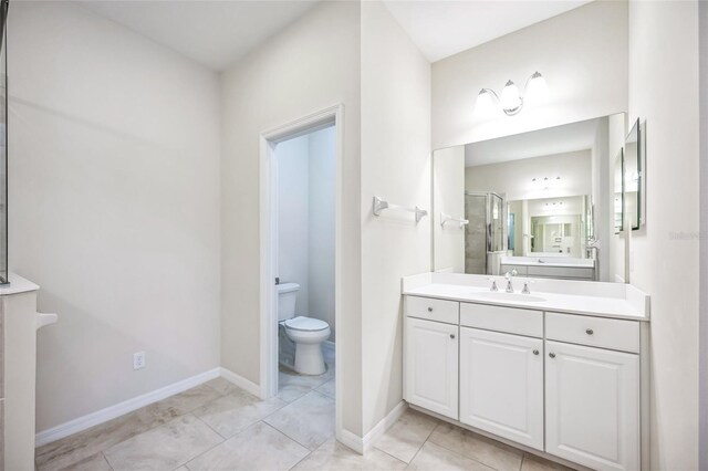 bathroom featuring tile patterned floors, vanity, toilet, and a shower with door