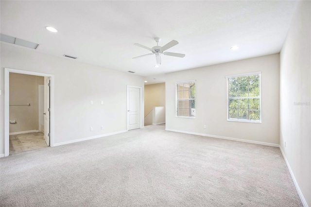 unfurnished bedroom with recessed lighting, light colored carpet, visible vents, ensuite bathroom, and baseboards