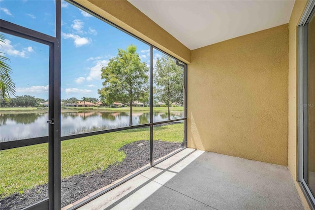 unfurnished sunroom featuring a water view