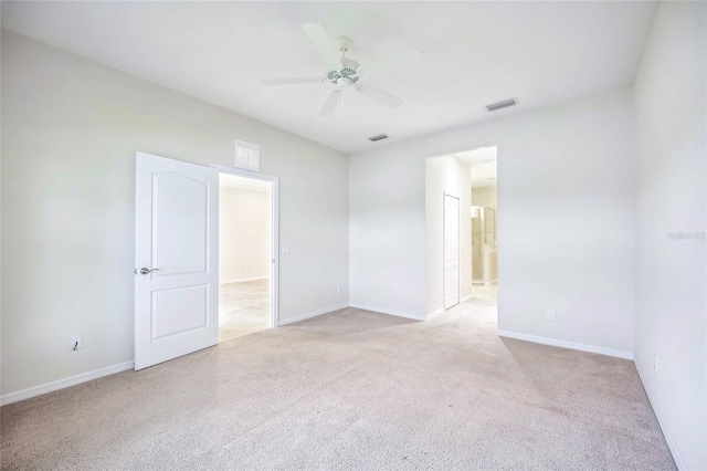 spare room with ceiling fan, light colored carpet, visible vents, and baseboards