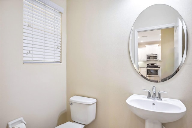 bathroom featuring plenty of natural light, a sink, and toilet