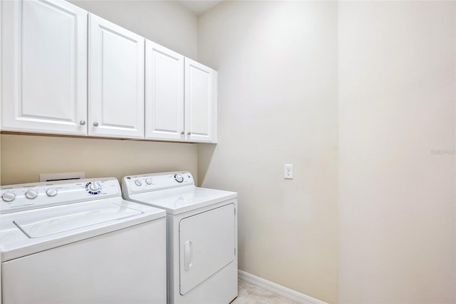 laundry area featuring cabinet space, baseboards, and independent washer and dryer