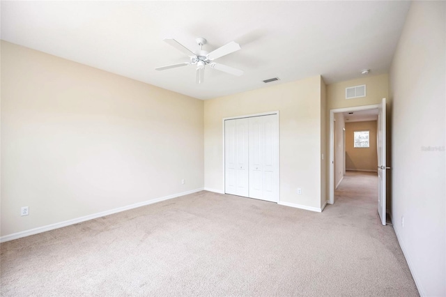 unfurnished bedroom with light colored carpet, a closet, visible vents, and baseboards