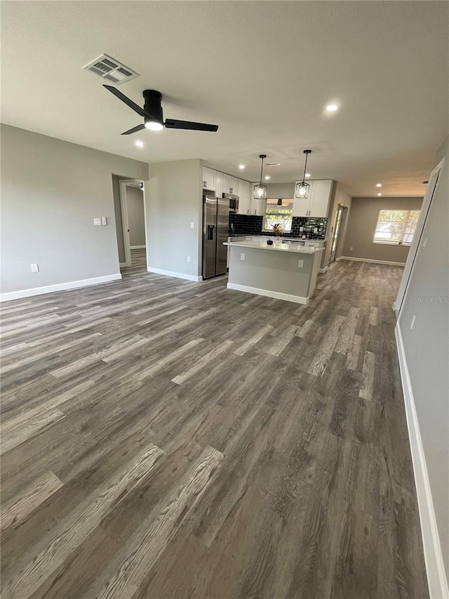 unfurnished living room with dark wood-type flooring and ceiling fan