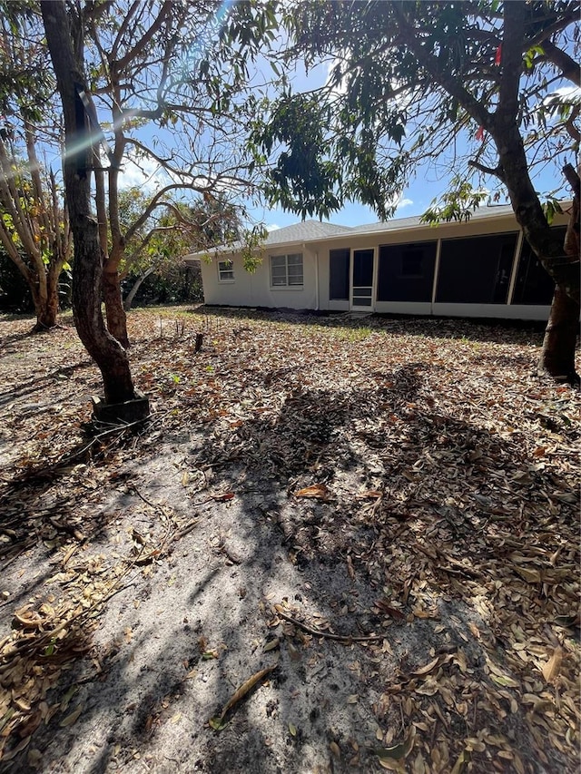 rear view of house featuring a sunroom