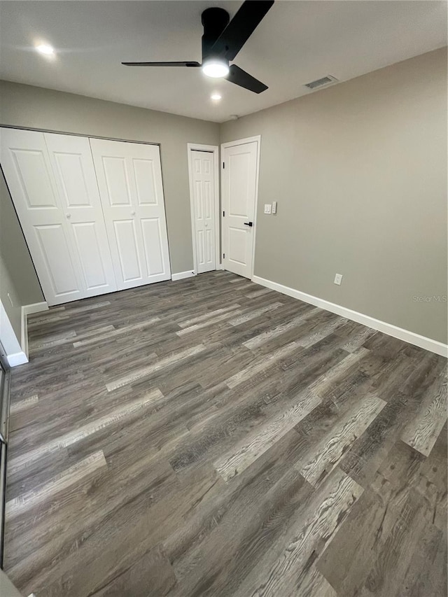 unfurnished bedroom featuring dark wood-type flooring and ceiling fan